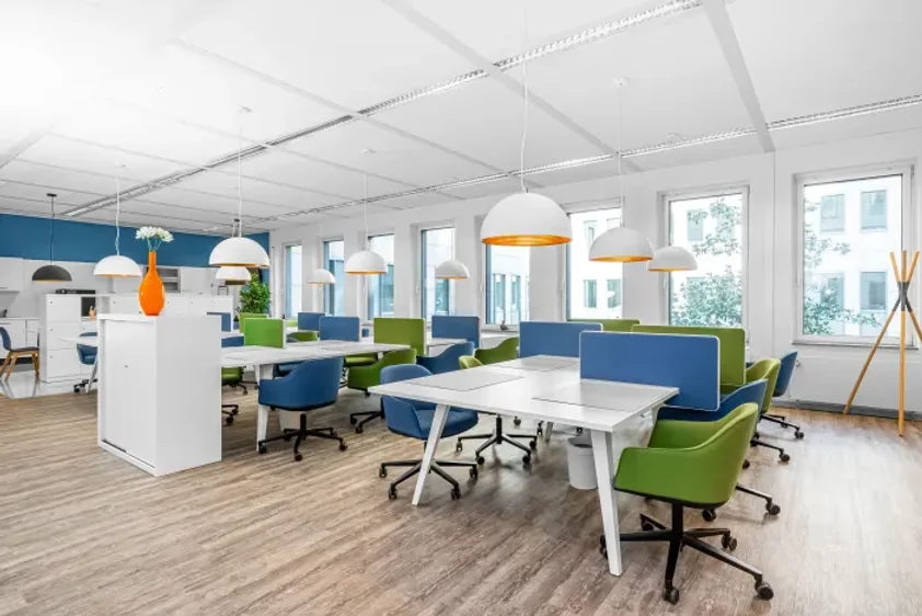 Espace de coworking du centre Regus Metz Lafayette, avec postes de travail colorés, chaises ergonomiques et grandes fenêtres lumineuses.