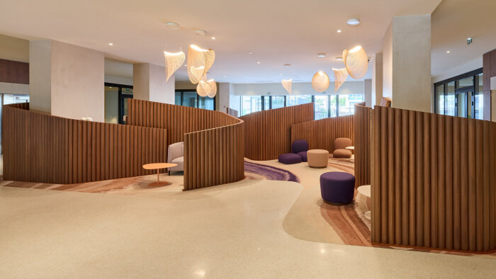 Lobby d’Audessa à Lyon : des alcôves boisées et un mobilier coloré pour un accueil chaleureux. - © ringuetphotographie.fr